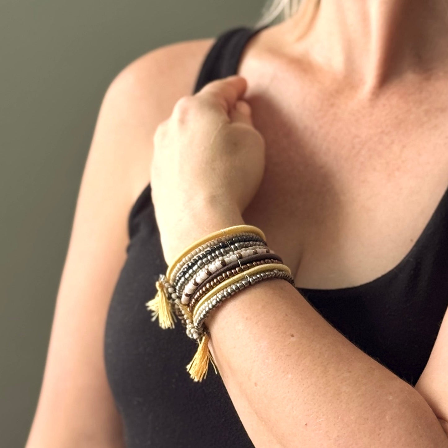 Simple bead stacking cuff bracelet handmade Bali in gold and black on a womans wrist