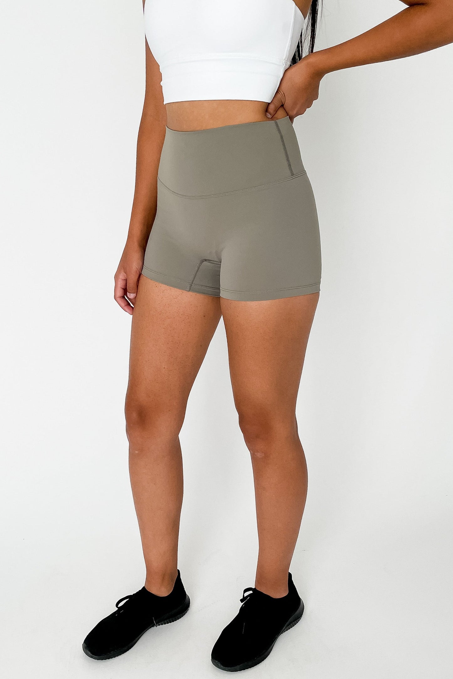 front view of woman wearing barely There 4" yoga shorts in bronzed green, lightweight squat-proof activewear