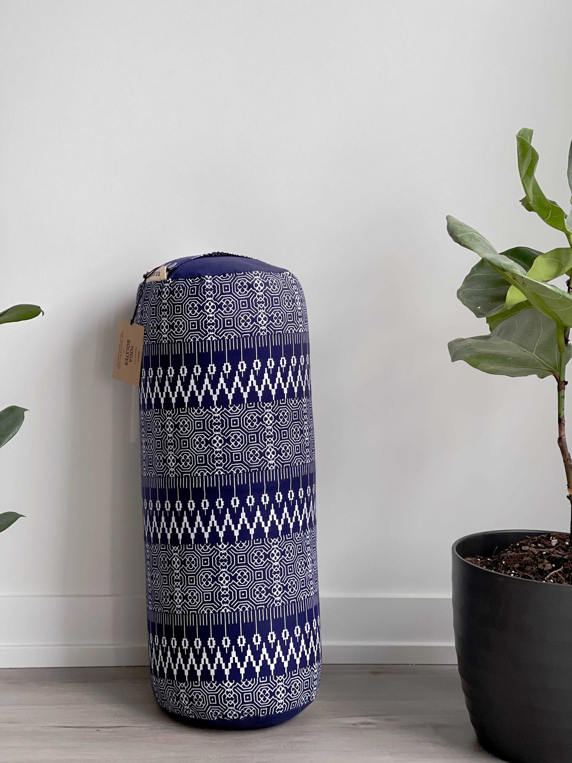 navy blue and white yoga bolster with geometric design against a wall