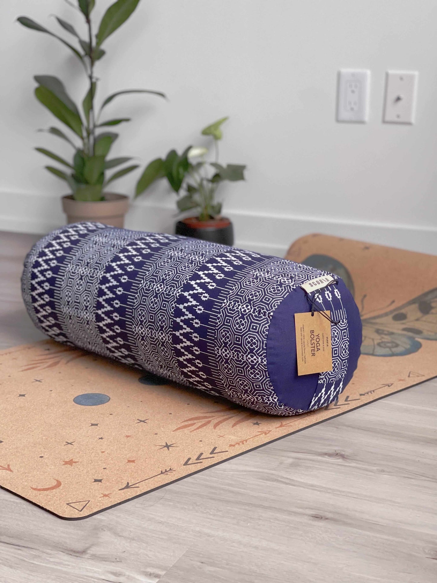 yoga bolster with tag on a yoga mat