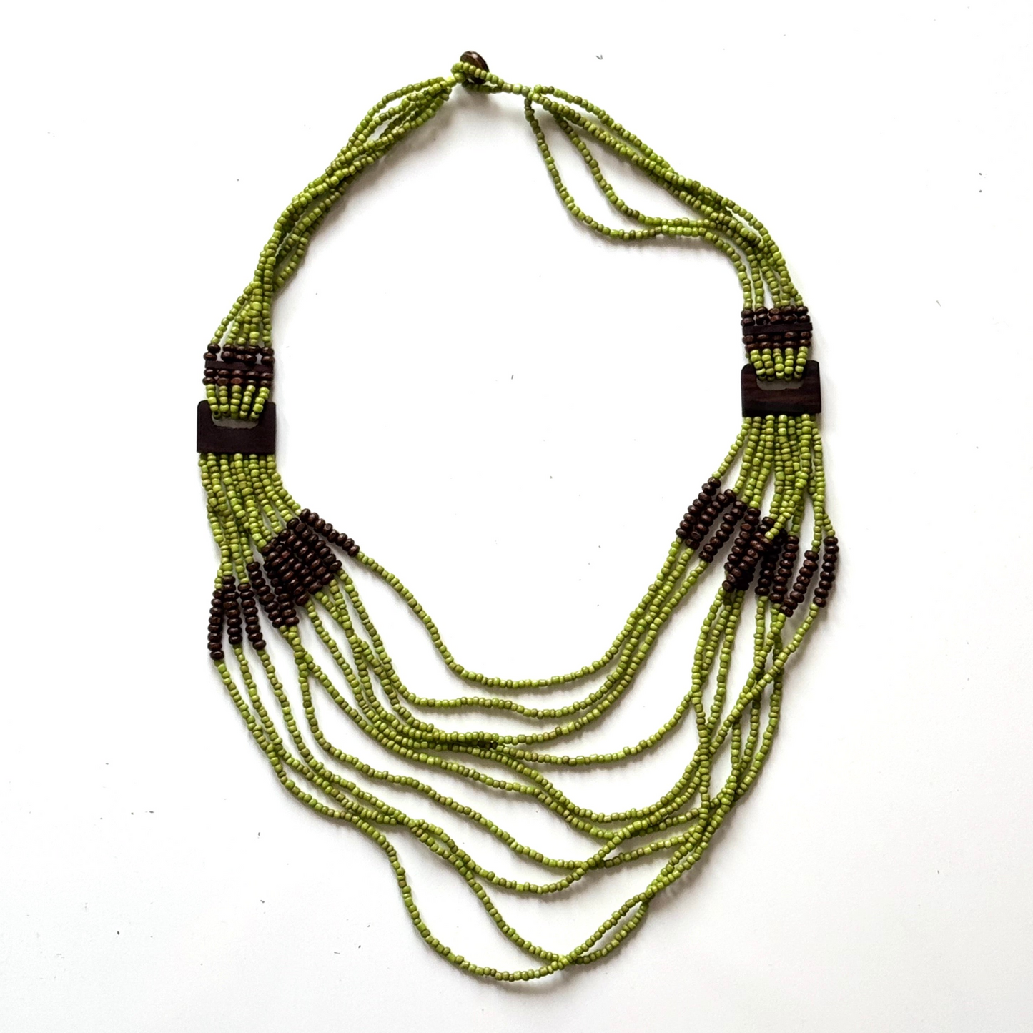 Green beaded necklace with black accents on a white background