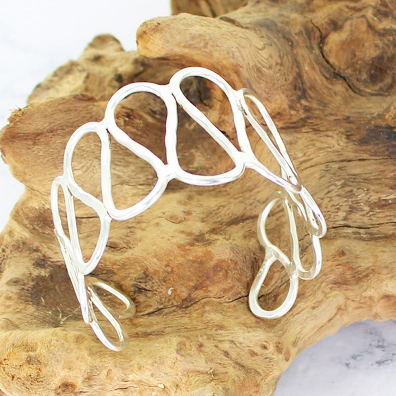 Adjustable silver loop cuff bracelet boho artisan jewelry on a branch