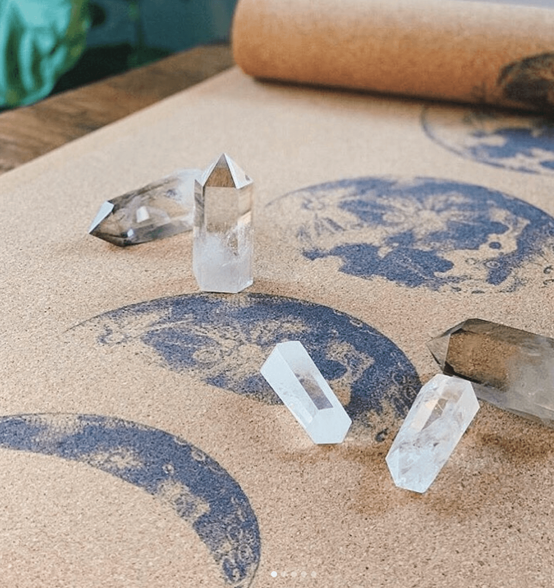Cork yoga mat with moon phase design and some crystals on top