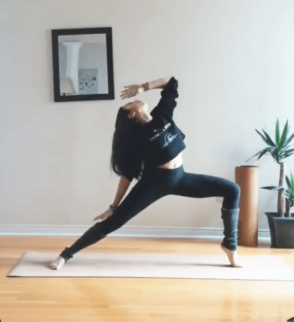 Person practicing yoga on a cork yoga mat n a home setting with a plant and mirror on the wall.
