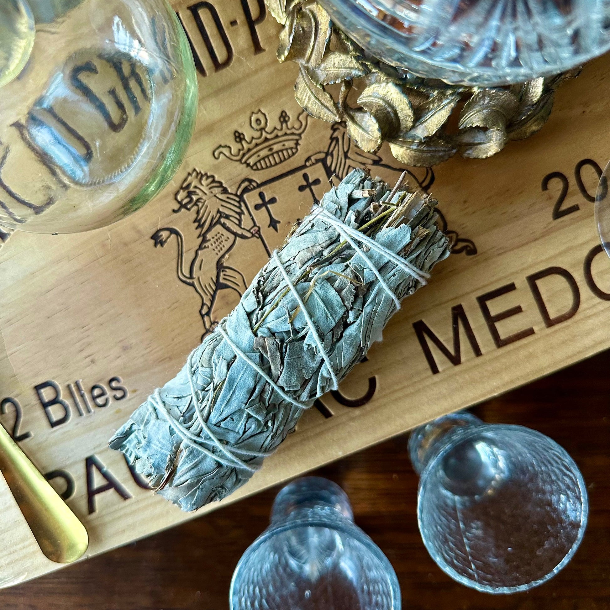 Bundled white sage on a wooden tray with 'Medicinal' branding
