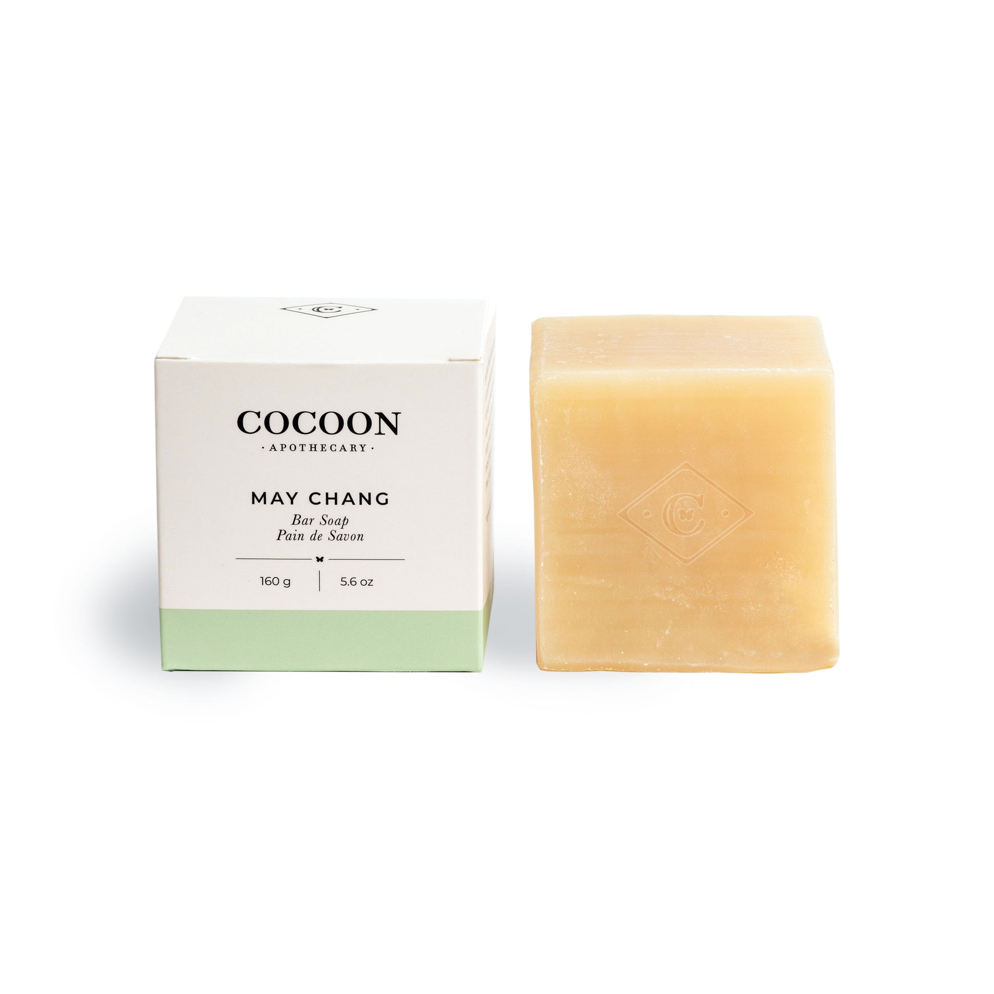 Bar of May Chang soap next to its packaging with 'Cocoon Apothecary' branding on a white background