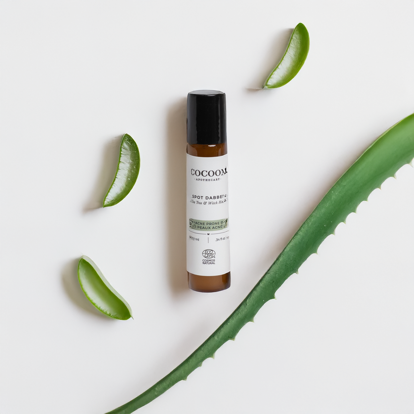 Roll-up bottle of Spot Dabber for Acne Prone Skin with aloe vera leaves on a light background
