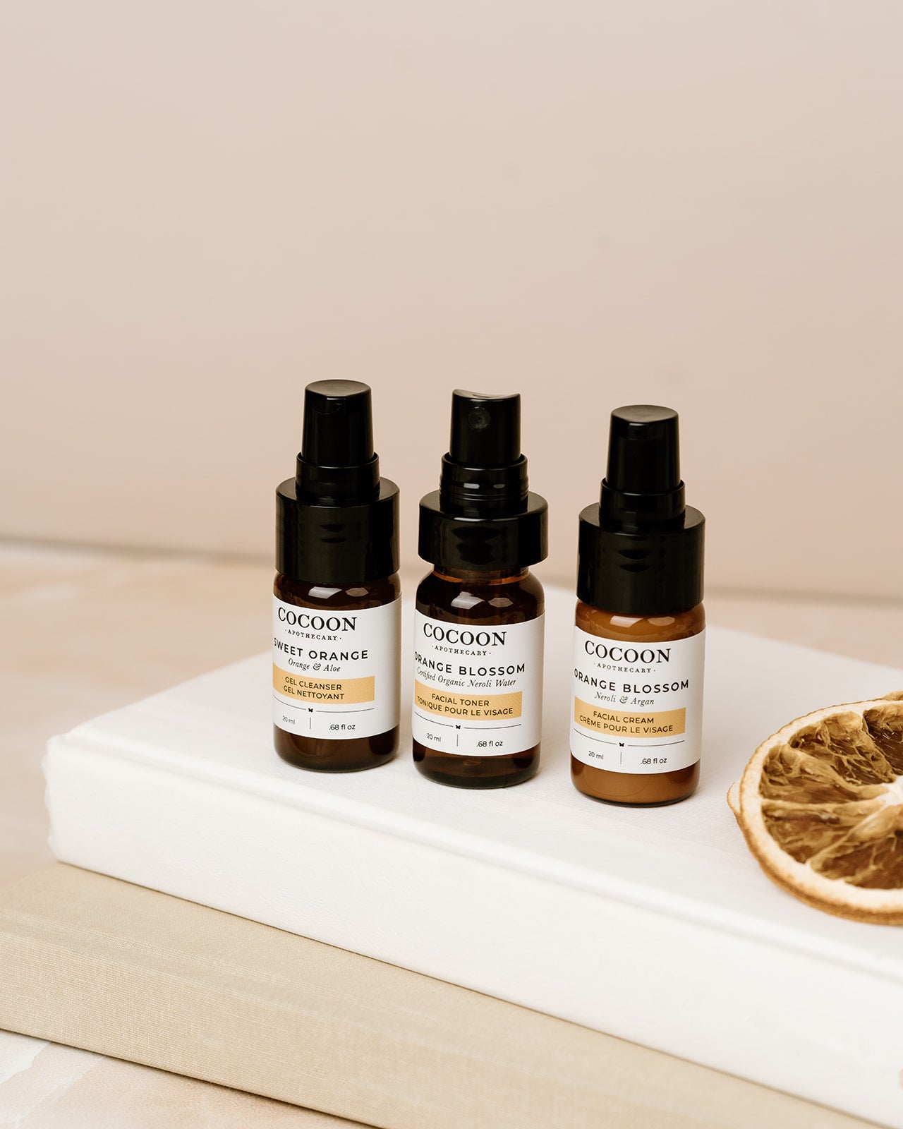 Three Cocoon skincare starter kit bottles on a white surface with a beige background