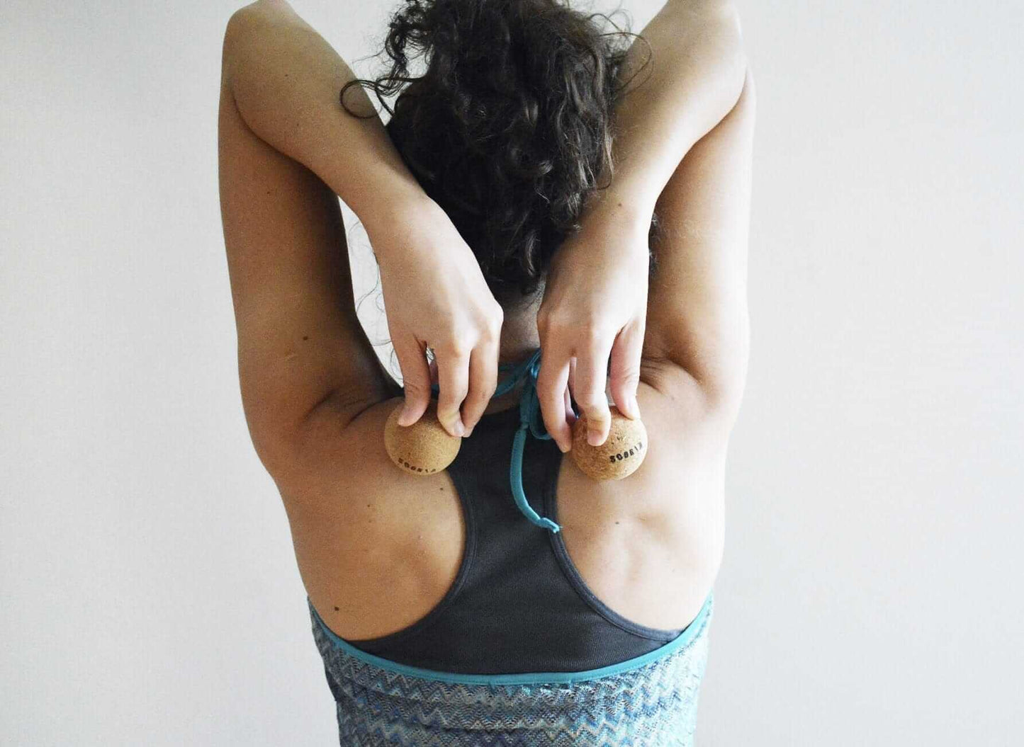 woman using cork roller balls to massage her back 
