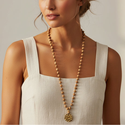 Long wood bead mala necklace with antique gold hammered medallion pendant worn by a woman — handmade in India for boho, spiritual, and yoga style