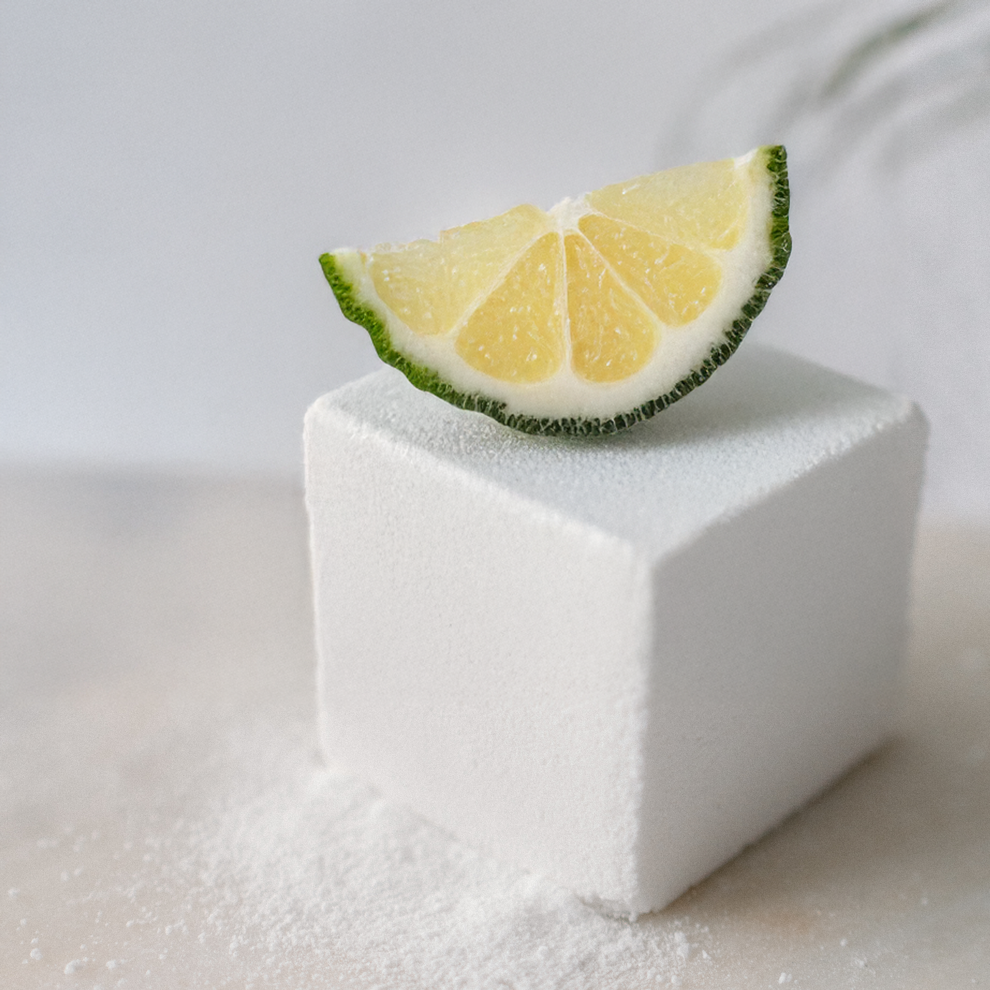 Citrus Tea bath cube with a slice of lemon on top against a white background