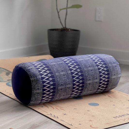 blue and white yoga bolster on a cork yoga mat