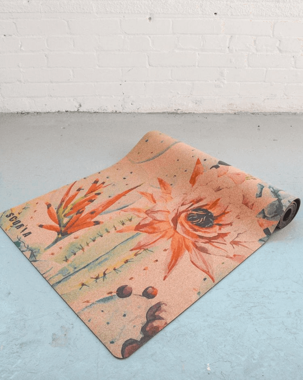 Yoga mat with floral design on a light blue floor.