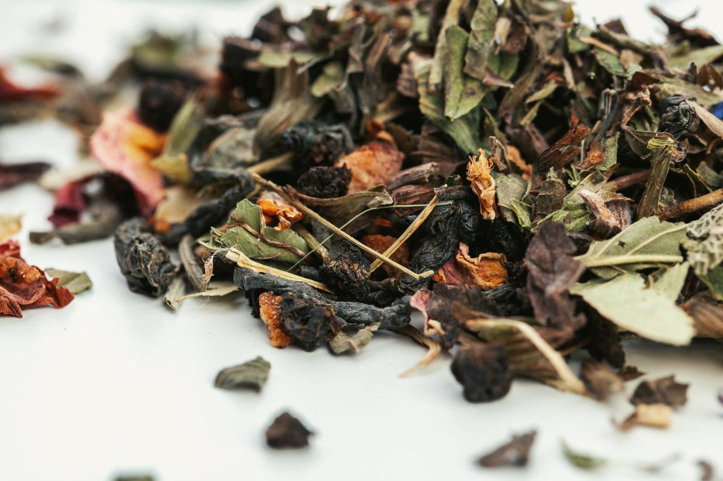 Close-up of dried tea leaves on a white surface