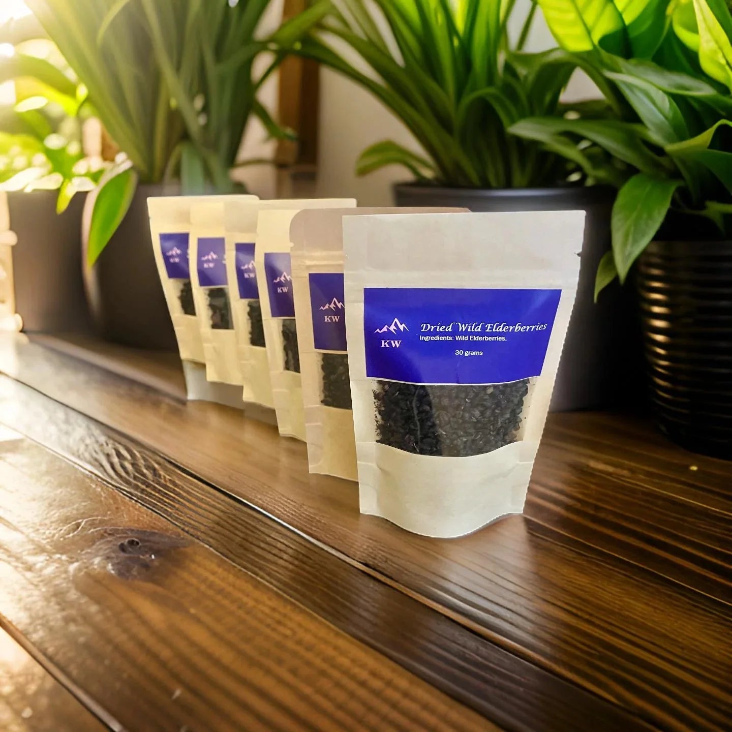 Packets of dried wild elderberries on a wooden shelf with plants in the background