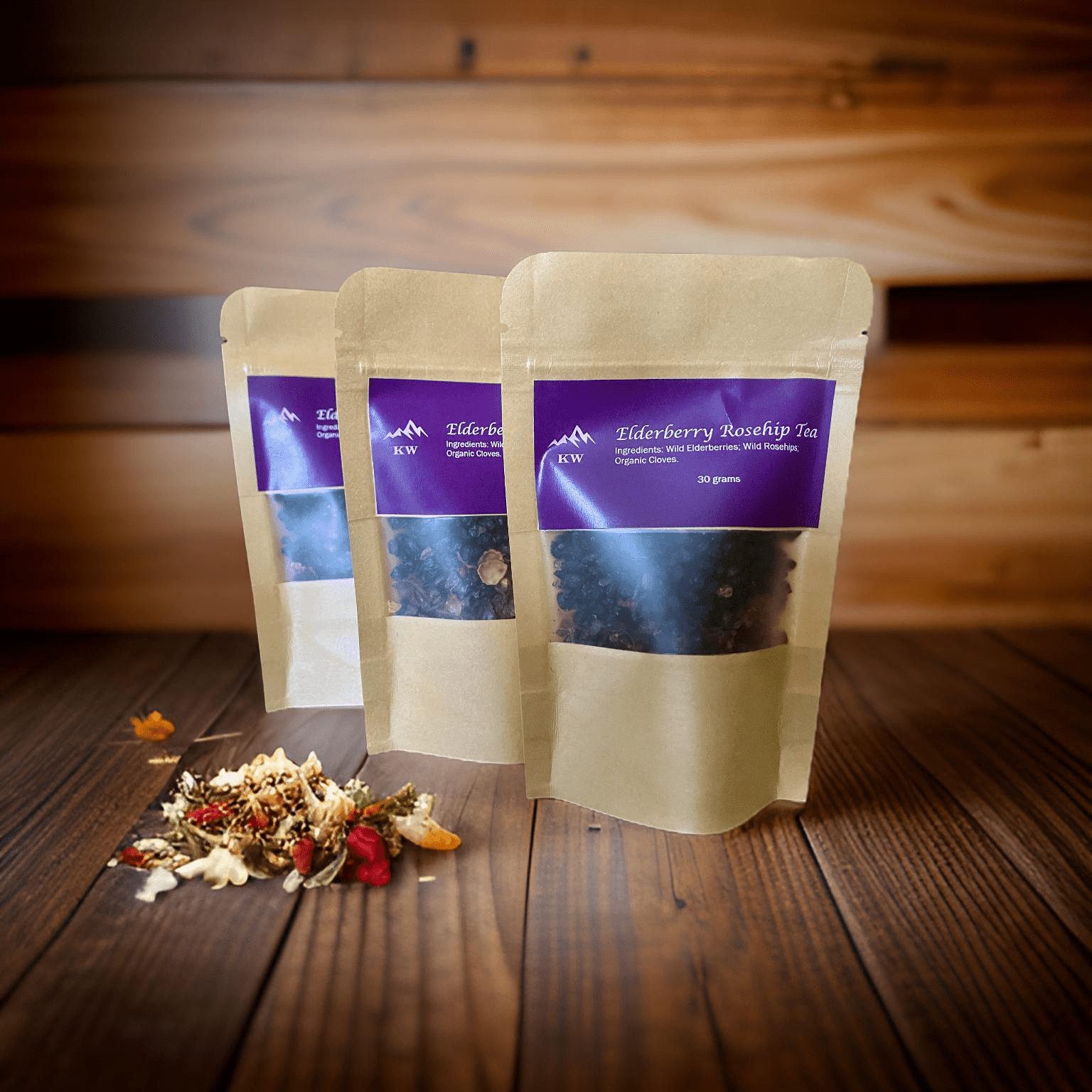 Three packages of Elderberry Roselin Tea on a wooden surface with dried herbs.