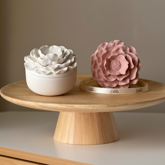Matte white flower lidded jesmonite trinket jar and dusty pink peony jesmonite sculpture styled on a dresser in warm natural light