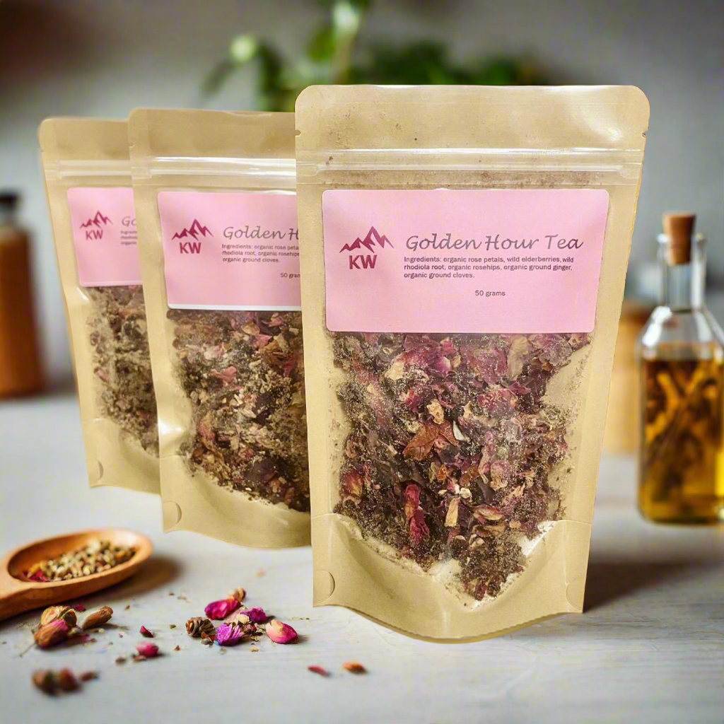 Three packages of Golden Hour Tea with pink labels on a light surface.