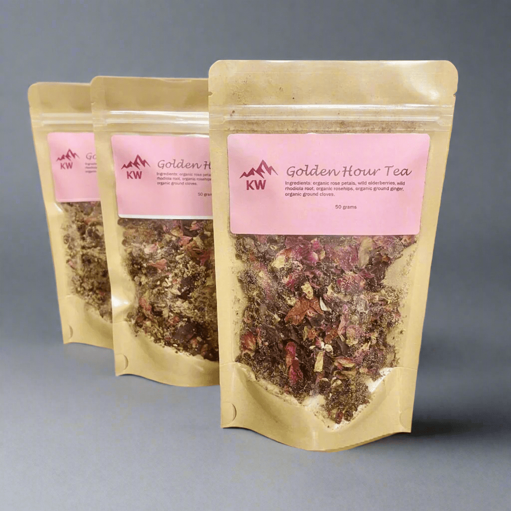 Three packages of Golden Hour Tea with pink labels on a gray background