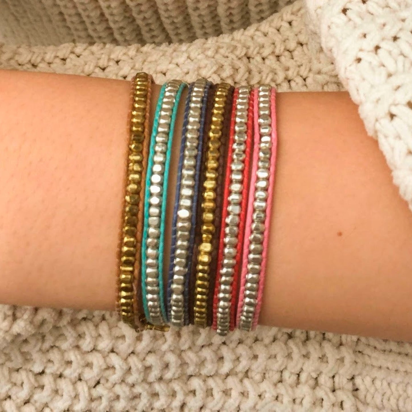 Close-up of a wrist wearing multiple colorful bracelets Handmade in India