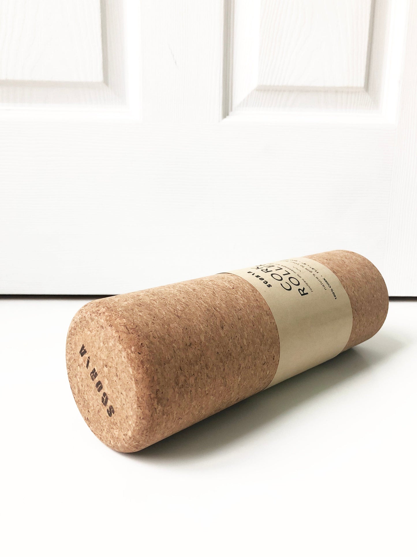 Cork yoga roller with a label on a white background
