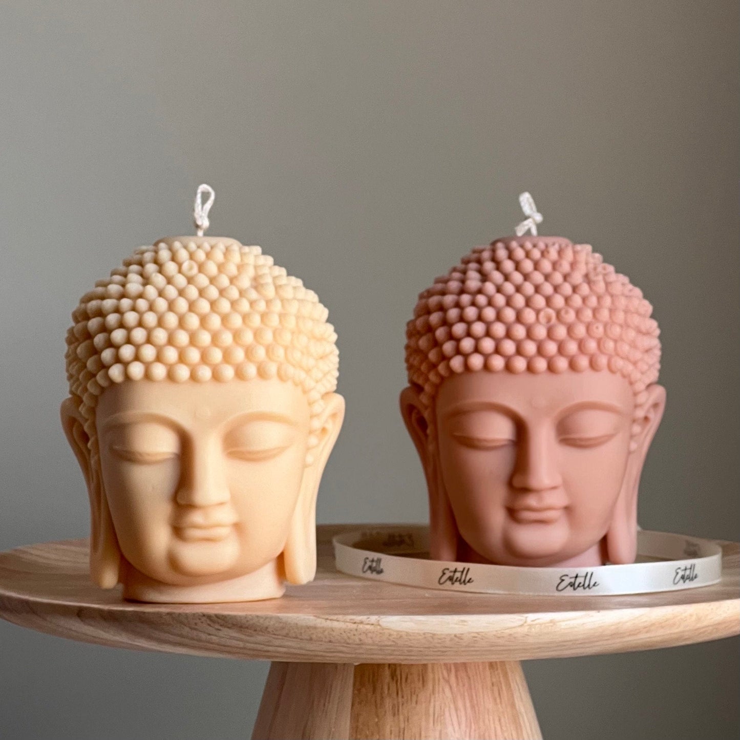 Buddha bust soy candle in two colors on display