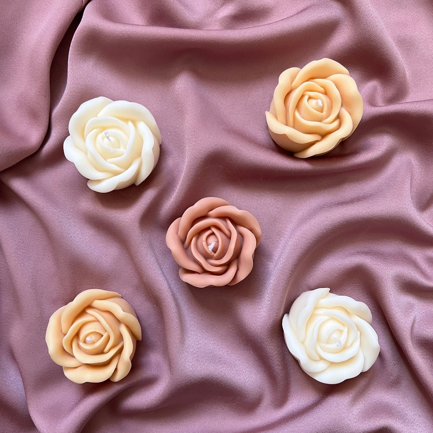 Small rose soy candle in three colors on display