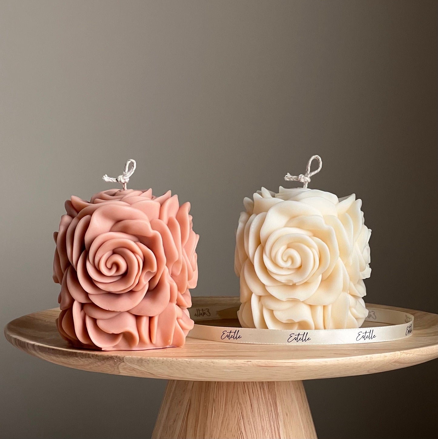 Handmade rose flower vegan soy pillar candle in two colors on display