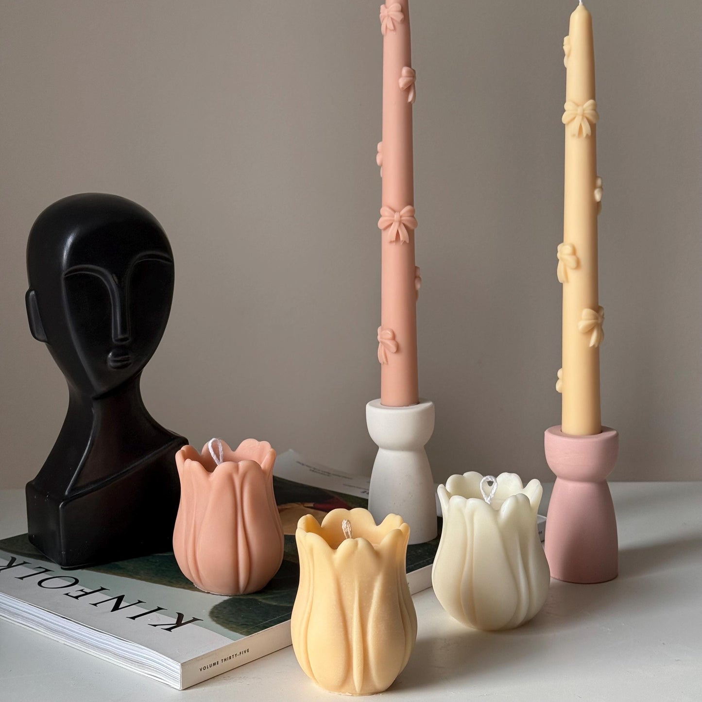 Tulip soy pillar candle in three colors on display with other items