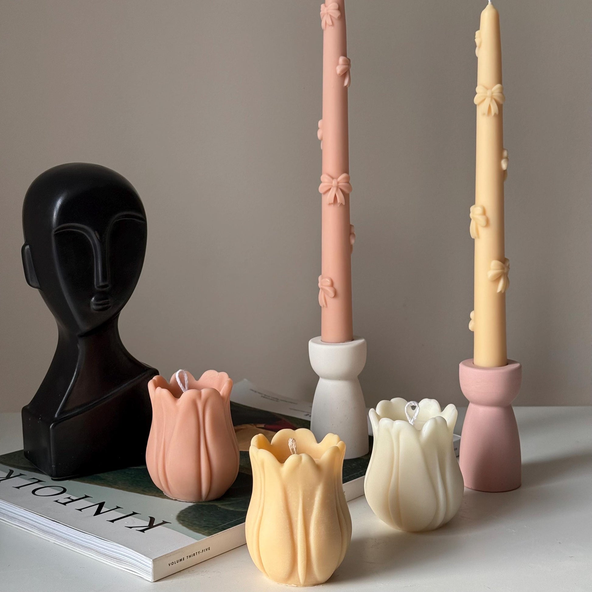 Tulip soy pillar candle in three colors on display with other items