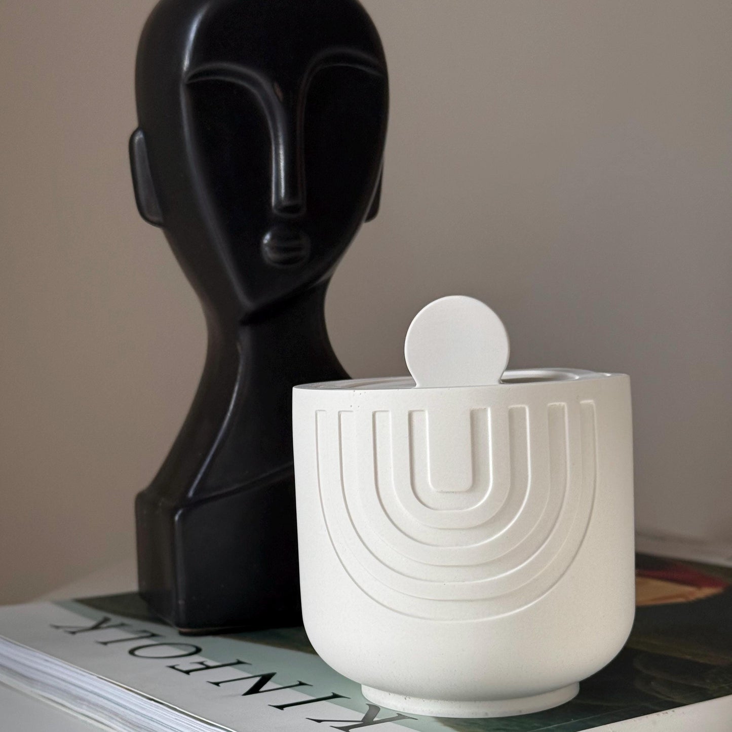 Scented soy candle in geometric jesmonite dish detail shot
