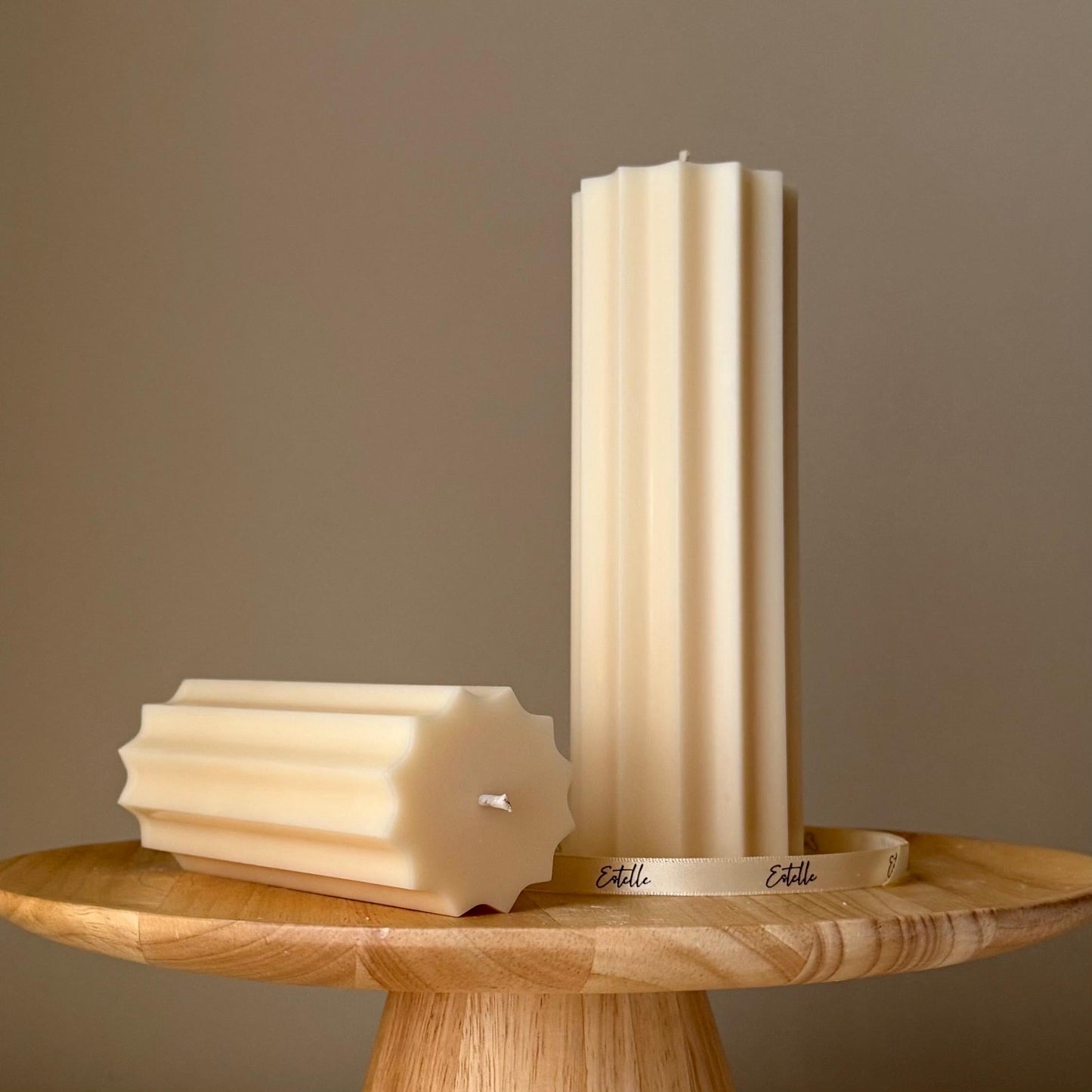 Large ribbed soy pillar candle in cream on display