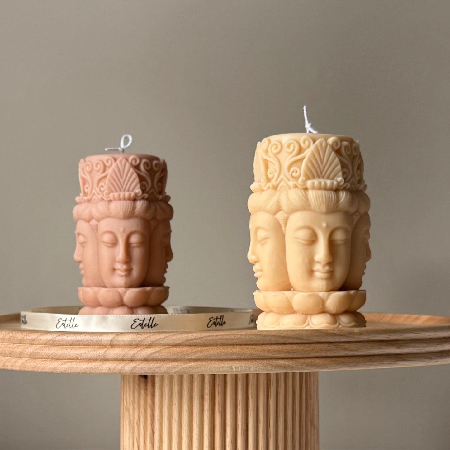 Buddha face soy pillar candle in two colors on display