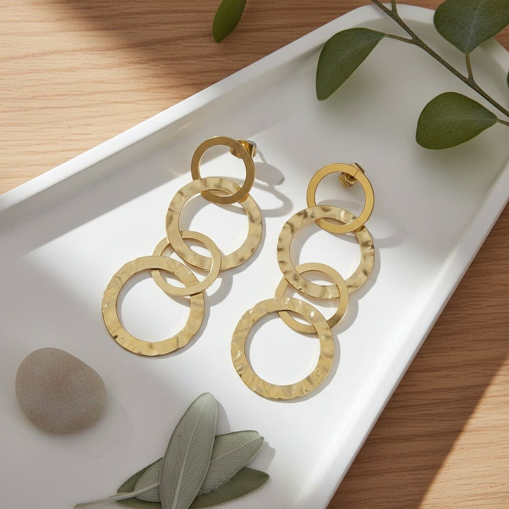 Gold stainless steel linked circle hoop earrings made in bali minimalist jewelry on a tray