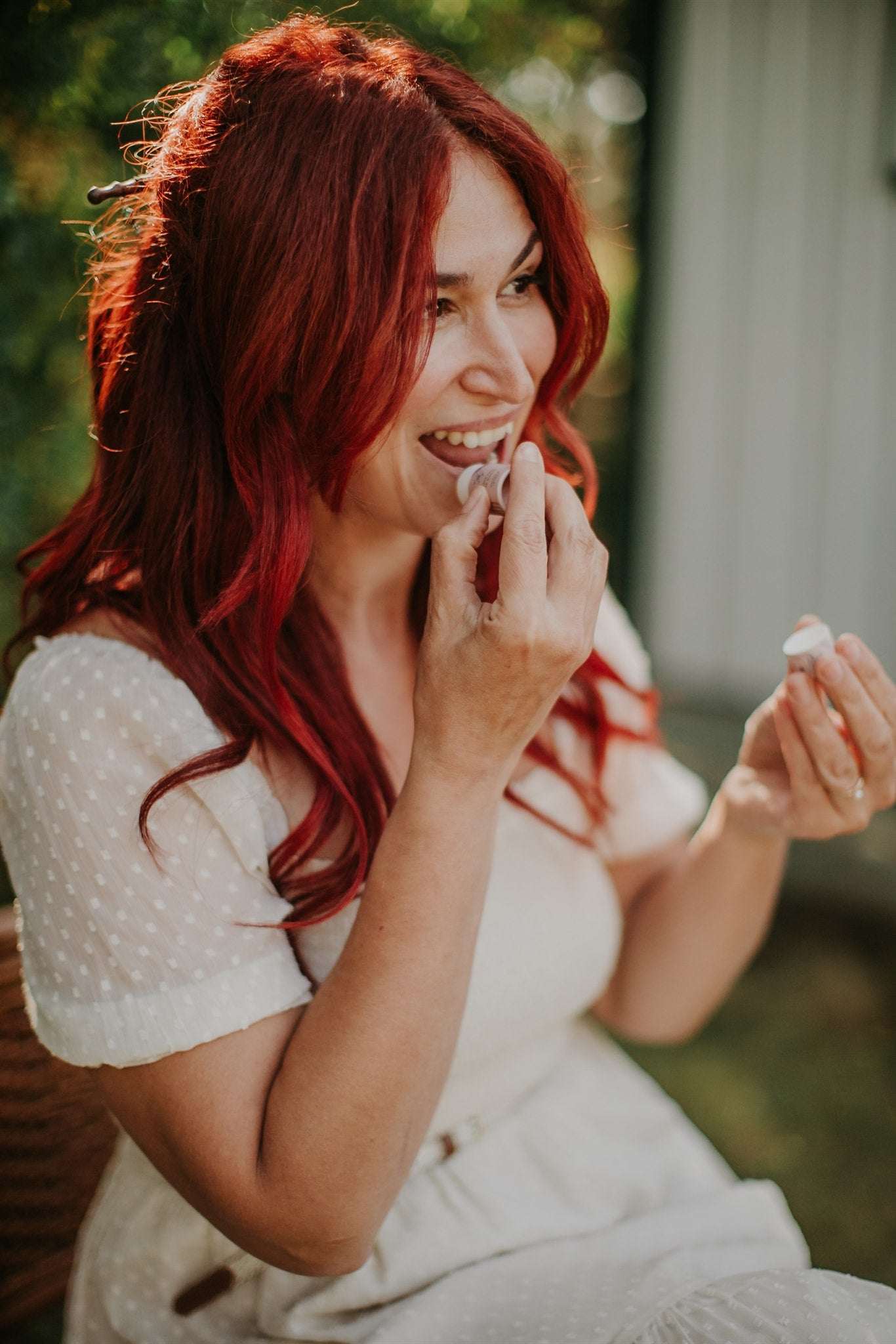 Woman with red hair lip balm makeup outdoors