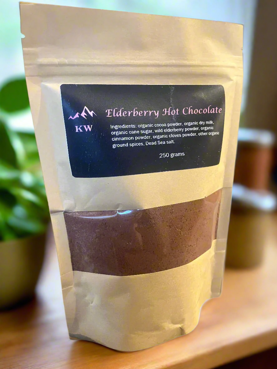 Package of elderberry hot chocolate with visible branding on a wooden surface.
