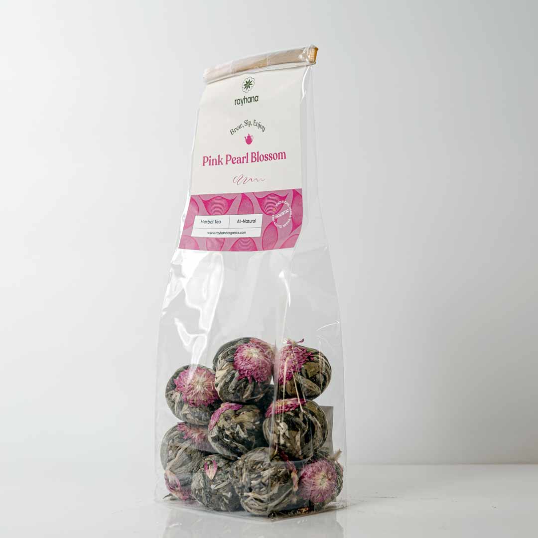 Pink pearl blossom tea ball blooming in hot water — floral display loose tea by Rayhana Organics