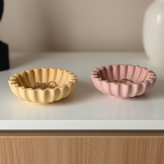 Pleated Dusty rose and sandy yellow pleated geometric jesmonite jewelry dishes with ruffled edges styled with gold rings on a dresser in warm natural light