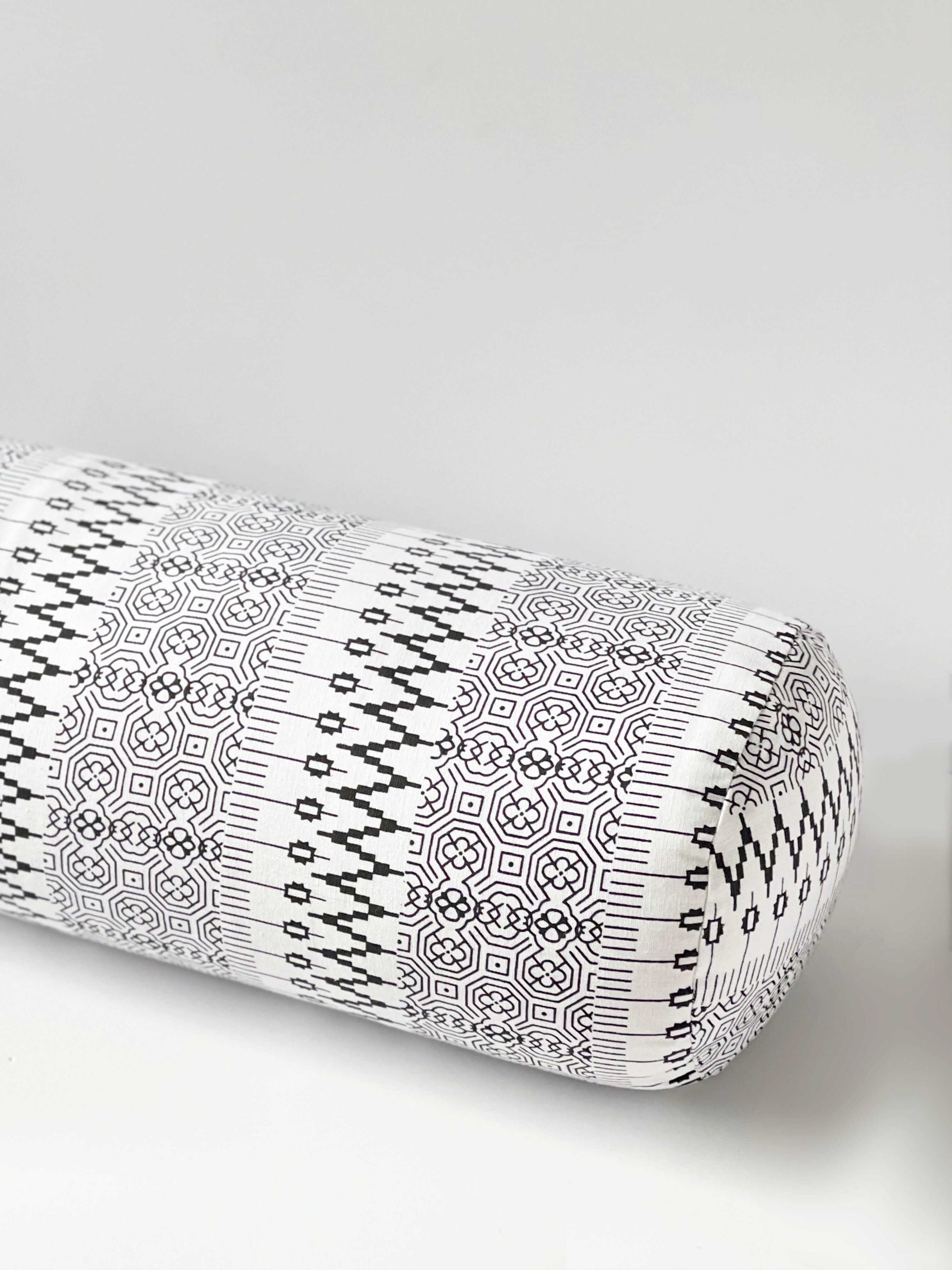 Yoga bolster with a black geometric pattern on a white background