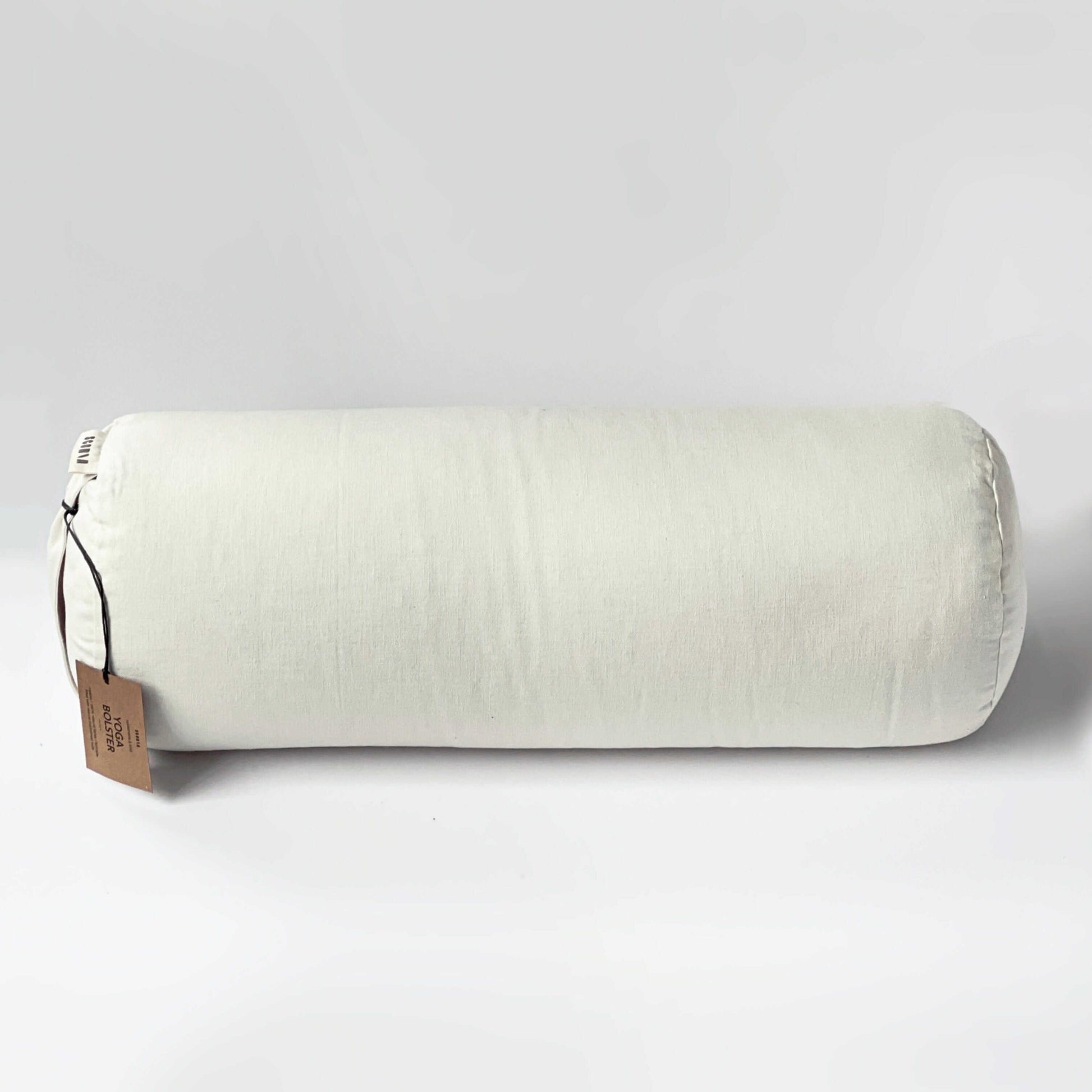 White cylindrical pillow with a brown tag on a light gray background