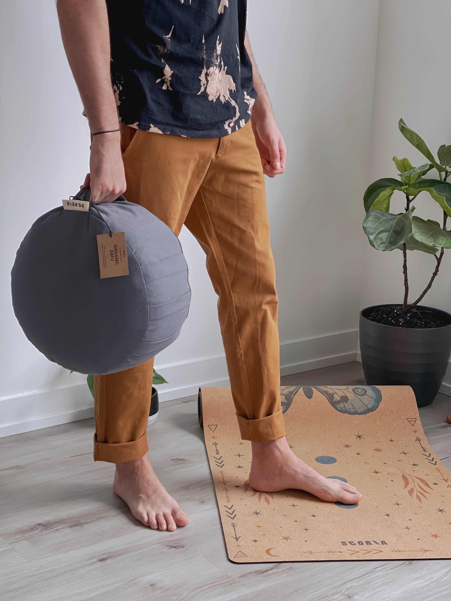 man holding a grey yoga cushion 