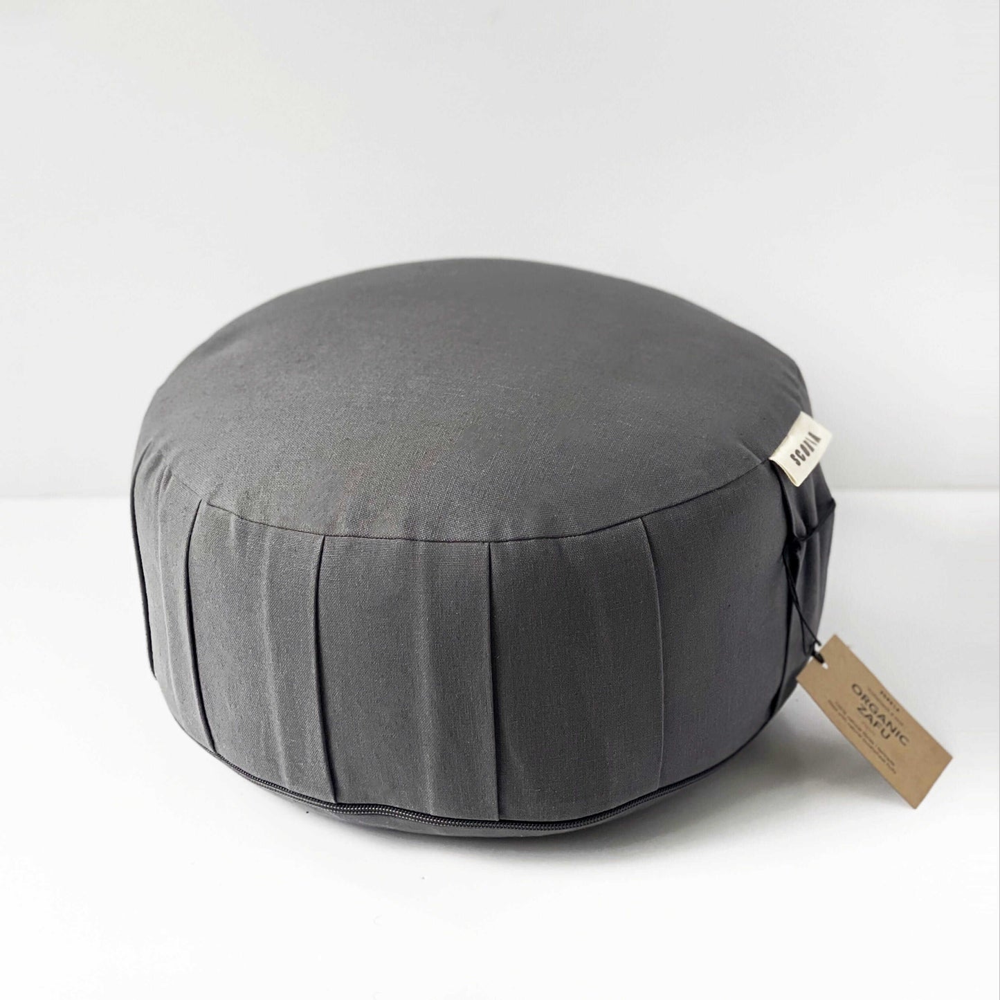 Gray meditation pillow with a brand tag on a white background