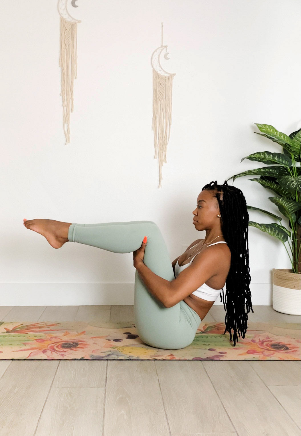 Woman practicing yoga in a home setting with a plant and colorful cork yoga mat.