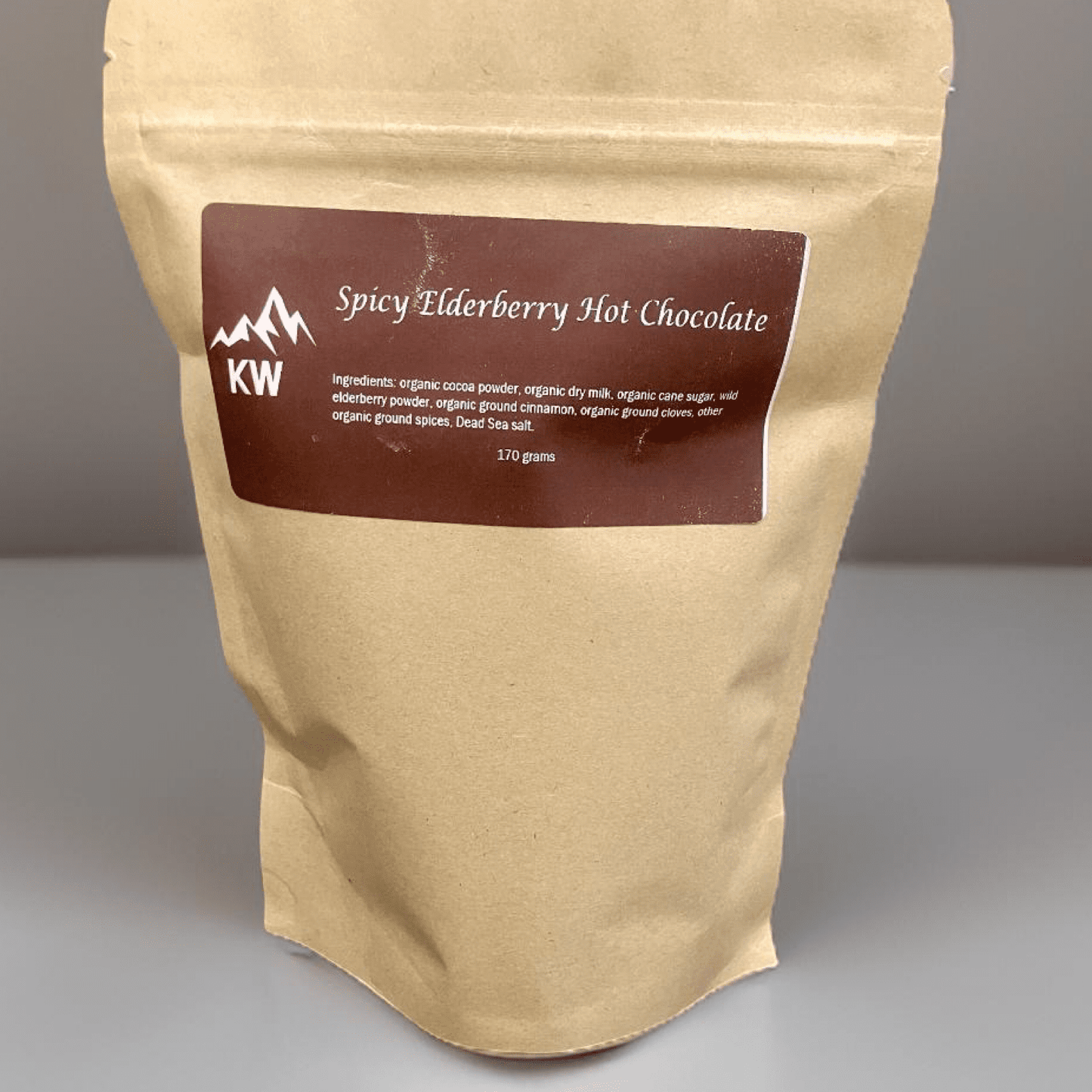 packaging of Spicy Elderberry Hot Chocolate with a brown label on a gray background