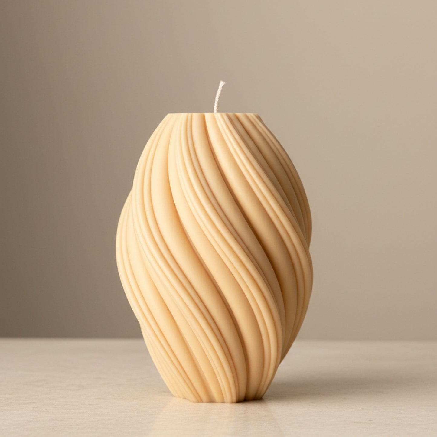 Warm sand cream oval wave ridge sculptural soy candle with diagonal flowing texture — Estelle Studio artisan statement candle, modern home décor Canada