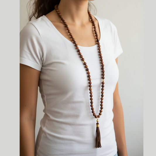 Extra long dark wood bead mala necklace with gold cap and leather tassel worn by a woman — handmade in India, dramatic length to the hip for boho, yoga, and spiritual style